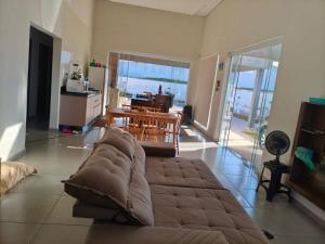 a living room with a couch and a table and a kitchen at Casa Condomínio Ninho Verde II in Pardinho