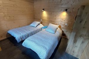 two beds in a room with wooden walls at La grange du vezou in Paulhenc +16 photos