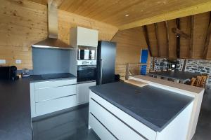 a kitchen with white cabinets and a black counter top at La grange du vezou in Paulhenc