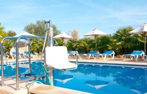 a pool at a resort with chairs and umbrellas at Finca Sa Pedrera in Can Picafort