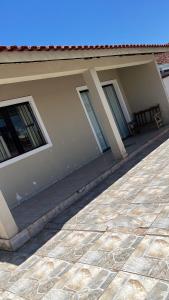 a house with two windows and a patio at Casa ilha comprida perto da praia in Ilha Comprida +1 photo