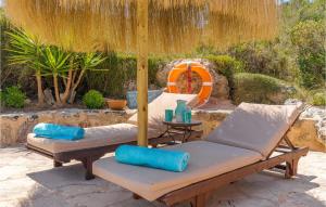 a patio with two lounge chairs and an umbrella at Es Socorrat in Portocolom