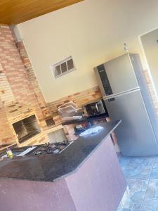 a kitchen with a stove and a refrigerator at Casa ilha comprida perto da praia in Ilha Comprida