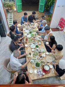 a group of people sitting around a table eating food at Con Cua Biển Homestay in Tuy Hoa