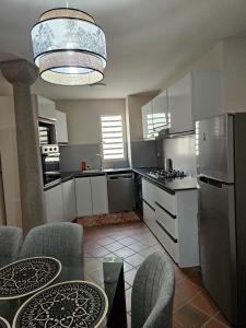 a kitchen with white cabinets and a table with chairs at Riverfront Villa 069 in Terre Rouge