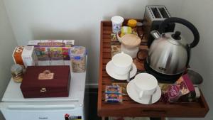 a table with a tea kettle on top of a refrigerator at Jan's Boutique B & B Suite in Christchurch