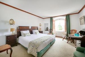 a bedroom with a large bed and a desk at Quinta da Alcaidaria Mor in Ourém