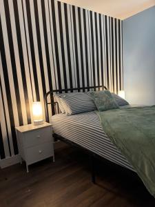 a bedroom with a bed and a striped wall at House FLL airport in Fort Lauderdale