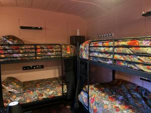 a room with three bunk beds with blankets and a mattress at BOHOSTEL in Macclesfield