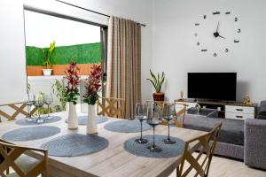 a dining room table with wine glasses and a tv at Villa Clif-Beau in Albion