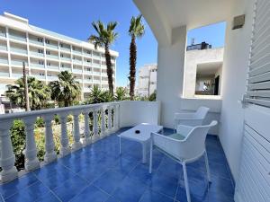 a balcony with chairs and a table and a building at ItineraBaiaVerde Rooms & Breakfast in Gallipoli