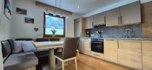a kitchen with a table and a couch in a room at Apart Antonius in Pfunds