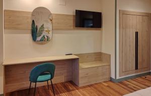 a room with a desk and a blue chair at HOTEL RST. PADORNELO in Padornelo