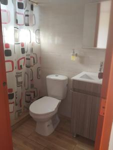 a bathroom with a toilet and a sink at Cabaña Mirador Angelita in Nuevo Colón
