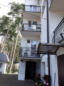 a white building with balconies on the side of it at Pod Sosnami 46 in Pobierowo