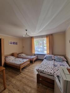 a room with three beds and a window at Pod Sosnami 46 in Pobierowo