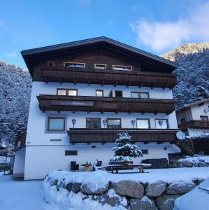 a building with snow on the ground in front of it at Apart Antonius in Pfunds