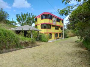 a yellow and red building on a hill at Casa de Huespedes "EL MOLINO" Oasis de Paz e Historia junto Antiguo Molino de agua a 10 min del Aeropuerto in Tababela