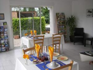 a dining room with a white table and chairs at Au Fil de l'Eau in La Ronde