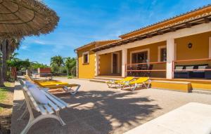 a yellow house with a group of tables and benches at Can Jaume Pollenca in Pollença +29 photos