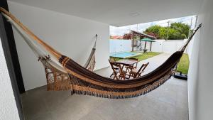a hammock in a living room with a table at Bela casa jacumã in Conde