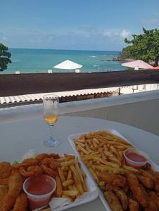 a table with a plate of food and a glass of beer at Habana Flats Praia in Natal