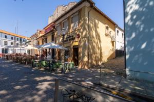 a street with tables and umbrellas next to a building at Authentic Porto Home by HostWise in Porto