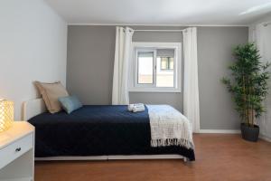 a bedroom with a bed and a window at Authentic Porto Home by HostWise in Porto