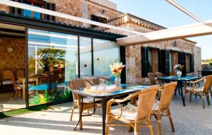 an outdoor patio with tables and chairs and glass doors at Sa Palmaria Dos in Can Picafort