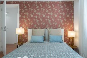 a bedroom with a bed with two blue pillows at Authentic Porto Home by HostWise in Porto