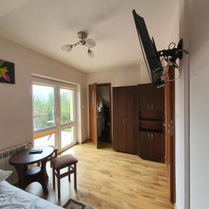 a room with a bed and a table and a television at Agro u Murzyna in Sienno