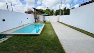a swimming pool in the backyard of a house at Bela casa jacumã in Conde