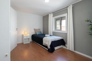 a small bedroom with a bed and a window at Authentic Porto Home by HostWise in Porto +11 photos