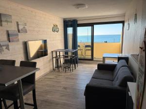 a living room with a couch and a table at Appartement face océan in Lacanau +6 photos