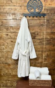 a white robe hanging on a wall with a basket at Agriturismo Tassinaia in Pontassieve