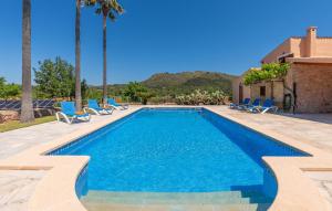 a swimming pool with blue chairs and a resort at Can Cremat in Artá
