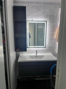 a bathroom with a sink and a mirror at Appartement face océan in Lacanau