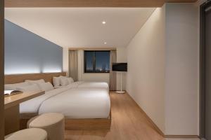 a bedroom with a large white bed and a window at 하로스테이 신사점 in Seoul