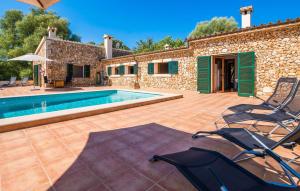 a villa with a swimming pool and two chairs at Can Baldo in Sencelles