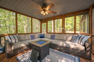 a screened in porch with a couch and a ceiling fan at Black Bear Lodge by Railey Vacations in Oakland