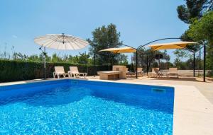 ein Swimmingpool mit zwei Sonnenschirmen, einem Tisch und Stühlen in der Unterkunft Ceratonia in Binissalem