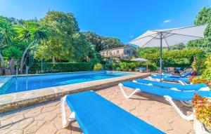 a swimming pool with lounge chairs and an umbrella at Ca Les Estamenyes in Pollença