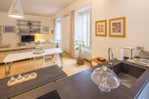 a kitchen and living room with a sink and a table at Casa Boutique Mareluna - Luxury Apartments by Mareluna Hotel in Salerno