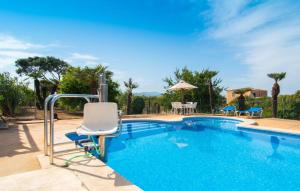 a swimming pool with a chair and a table and chairs at Sa Palmaria Dos in Can Picafort