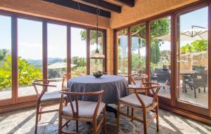 a dining room with a table and chairs and windows at S'alzinar Gran in Artá