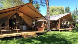 ein großes Zelt mit einem Picknicktisch in einem Garten in der Unterkunft Glamping Heidekamp in Versmold
