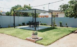 a gazebo with a table and chairs in a yard at Lelwapa Stay in Gaborone