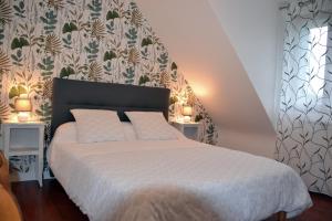 a bedroom with a bed with two tables and a wall at L' ESCALE SINAGOTE Chambre d'hôtes in Séné