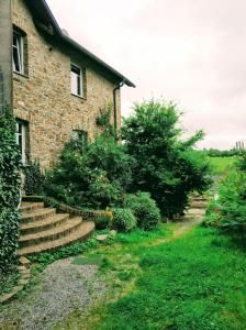 a brick house with stairs next to a yard at Au coeur de l'Ardenne - Peaceful loft in Baelen