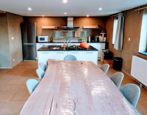 a kitchen with a long table and chairs in it at Au coeur de l'Ardenne - Peaceful loft in Baelen
